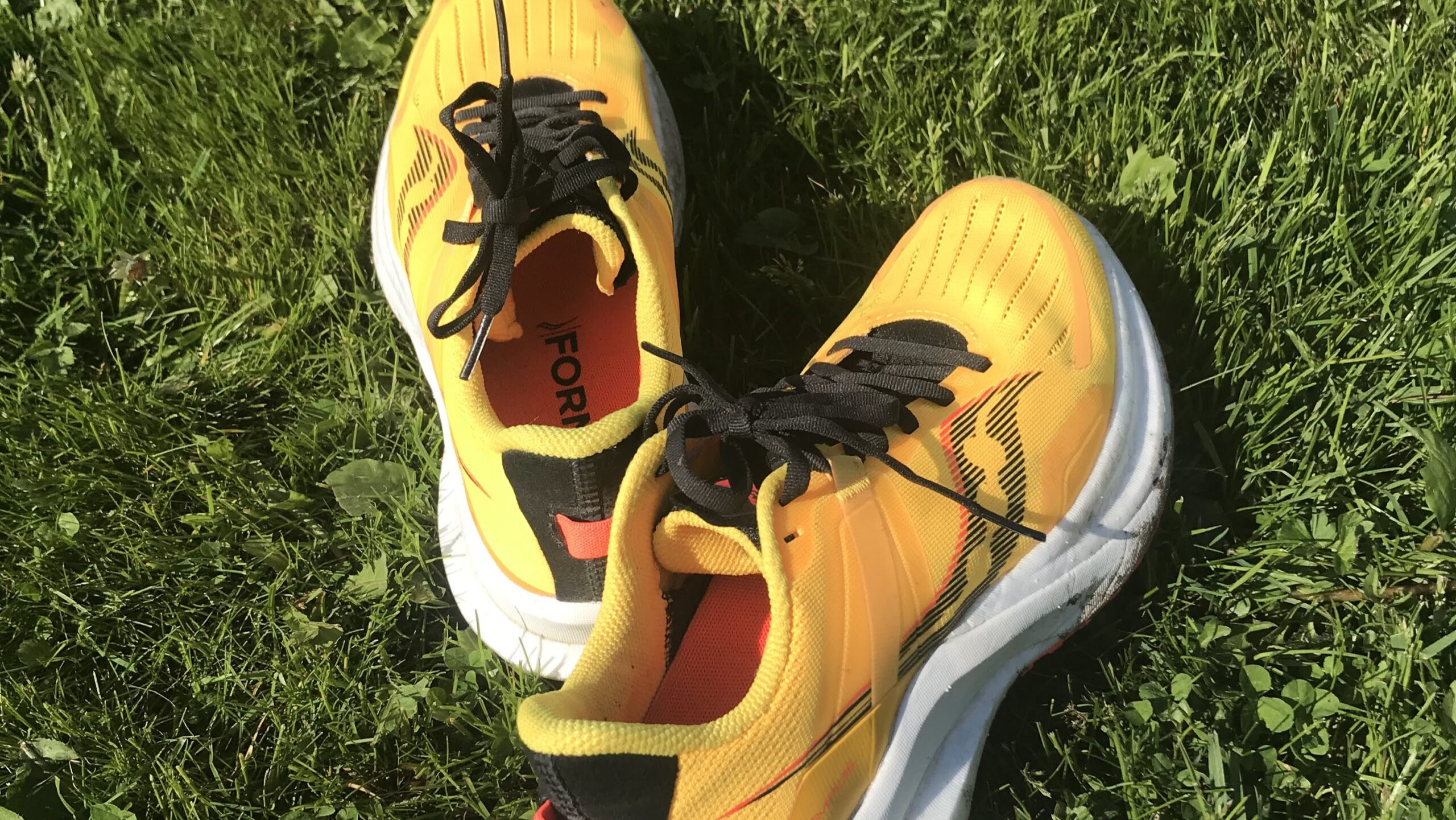yellow running shoes on grass