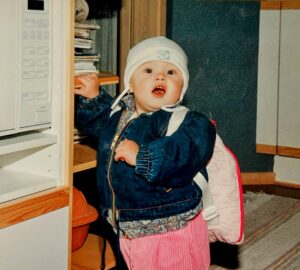 toddler standing next to microwave oven